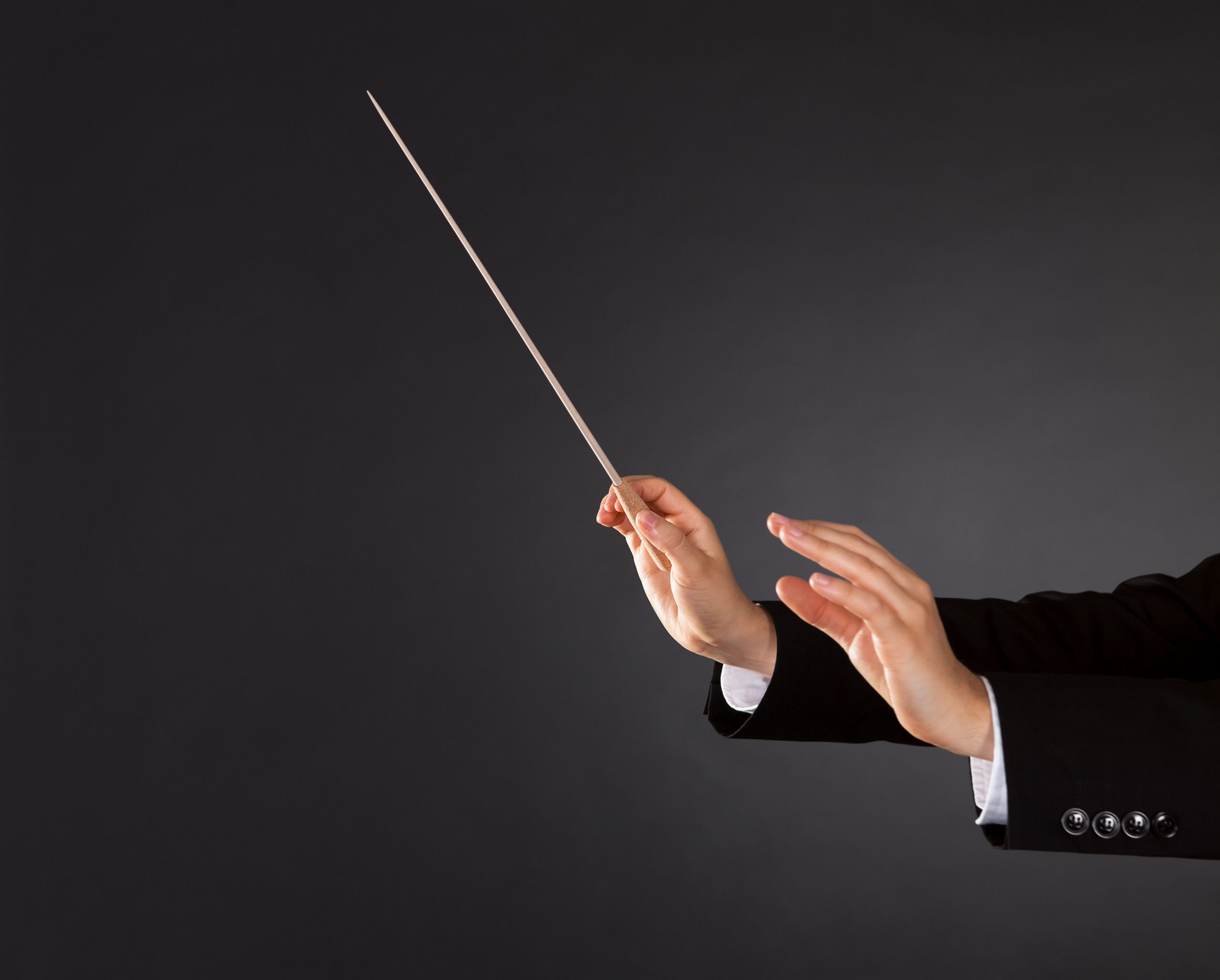 Business conductor hand with baton representing supply chain coordination