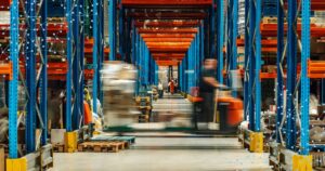 Forklift moving products quickly in warehouse with service logistics racks